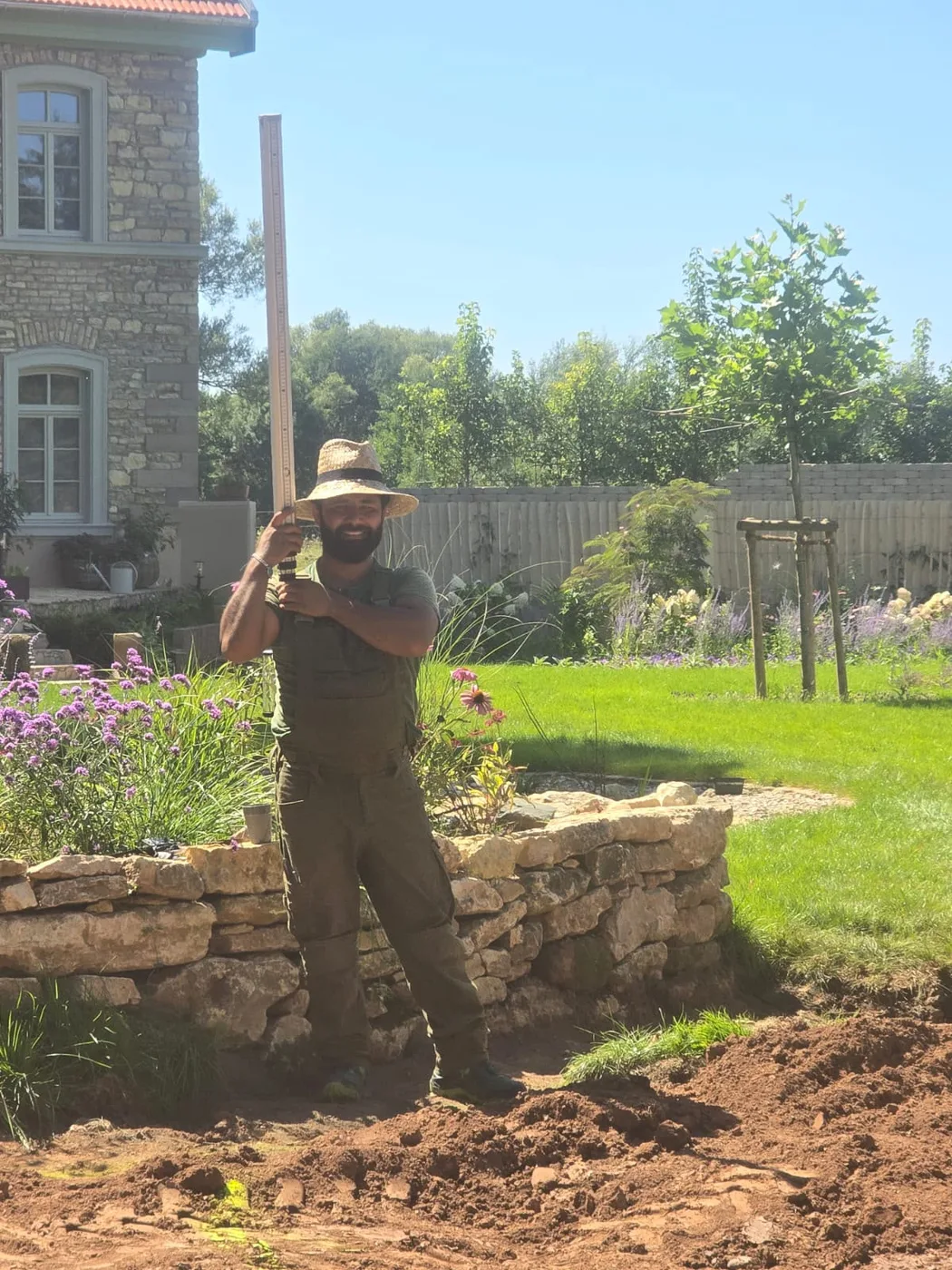 Mitarbeiter von Royal Garden beim Vermessen einer neuen Natursteinmauer im Garten